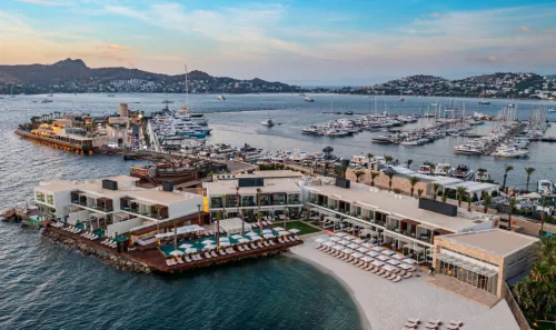 Bodrum Yalıkavak Araç Kiralama ile sahil yolunda manzara eşliğinde seyahat. Yalıkavak Şoförlü Araç Kiralama hizmeti Yalıkavak rent a car ile sahil yolunda yapılan keyifli sürüş, turkuaz deniz manzarası ve tatilciler için konforlu ulaşım deneyimini yansıta