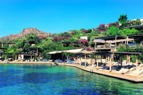 Travel along the coast with Bodrum Türkbükü Car Rental, accompanied by scenic views. A photo reflecting the enjoyable drive along the coast with Türkbükü car rental service, the turquoise sea view, and the comfortable transportation experience for holiday